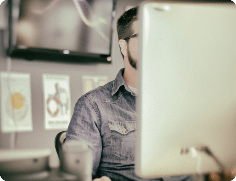 Utvecklare som arbetar framför datorskärm, symbol för tekniskt fokus och lösningar inom detaljhandel.