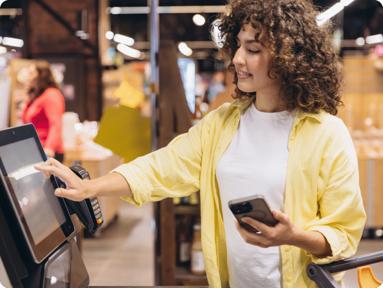 Kund använder självutcheckning i butik, symboliserar automatiserade flöden mellan kassa och affärssystem.